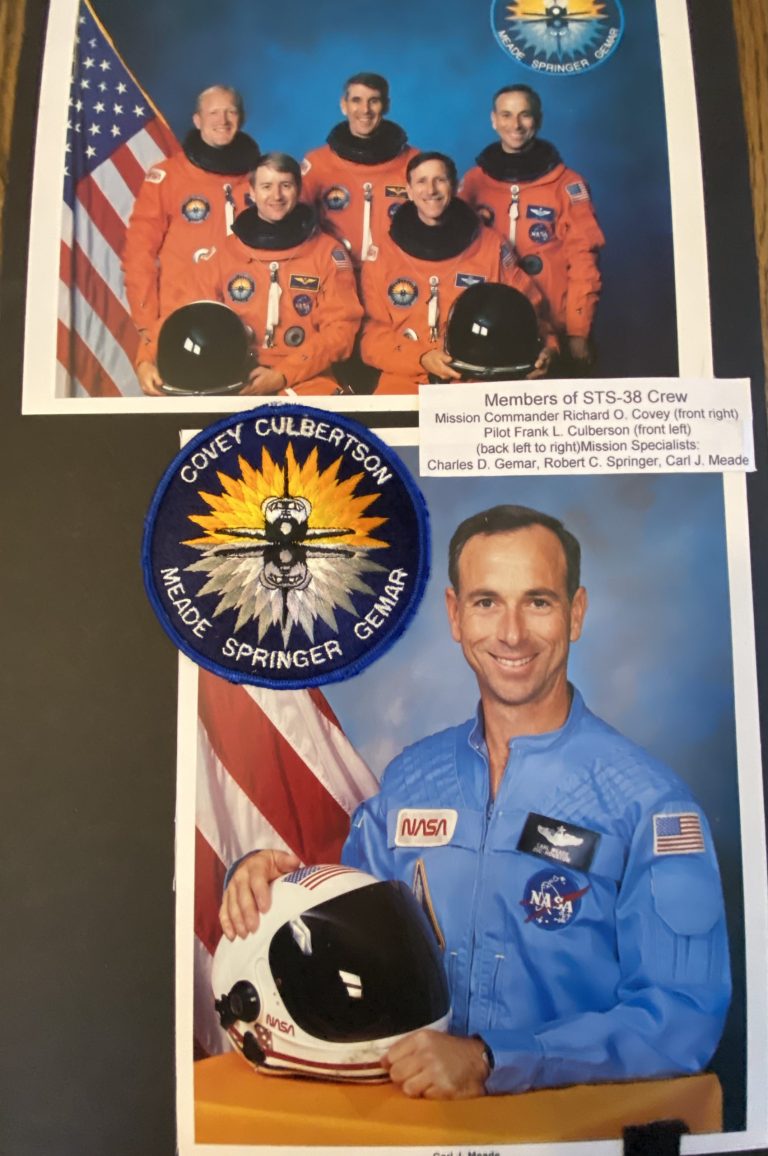 Astronaut Carl J. Meade holding his Longhorn Alumni Band vest in orbit